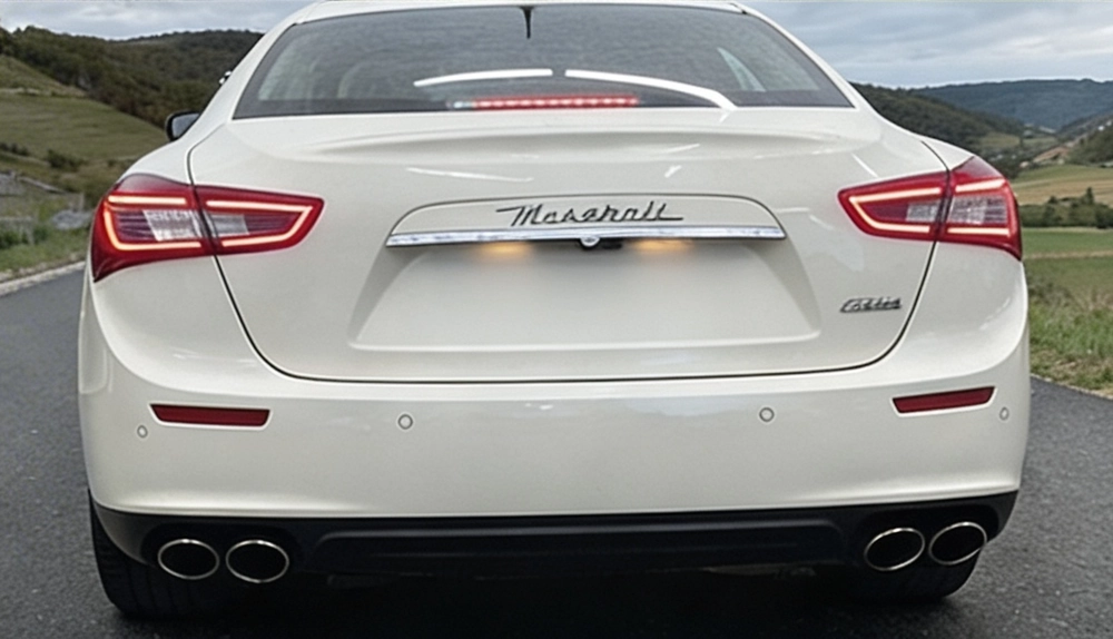 Maserati Ghibli blanche au bord d'un lac en pleine nature